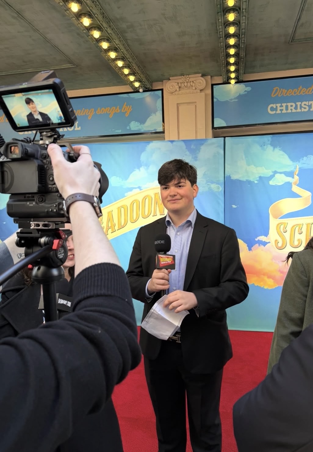 Gabriel Jaffe interviewing on a Broadway red carpet with a Broadway World microphone